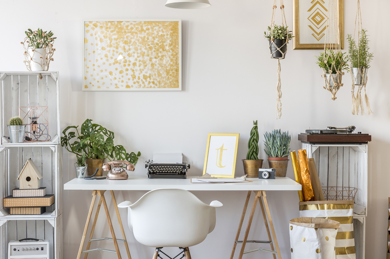A nice white home office decorated with books and plants at Emerald Springs Townhomes  in Detroit MI